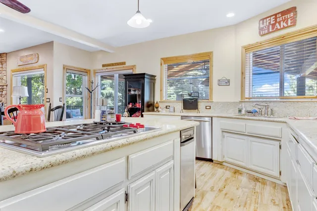 a kitchen with kitchen island granite countertop a sink cabinets and window