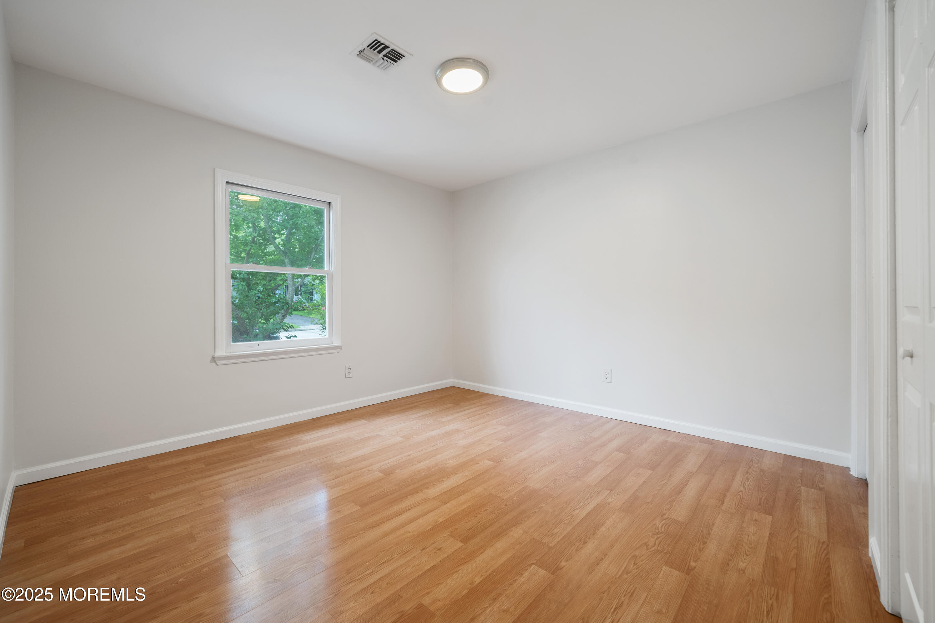 168 Stowaway Road Manahawkin, NJ 08050 - Photo 13 of 15 an empty room with wooden floor and windows