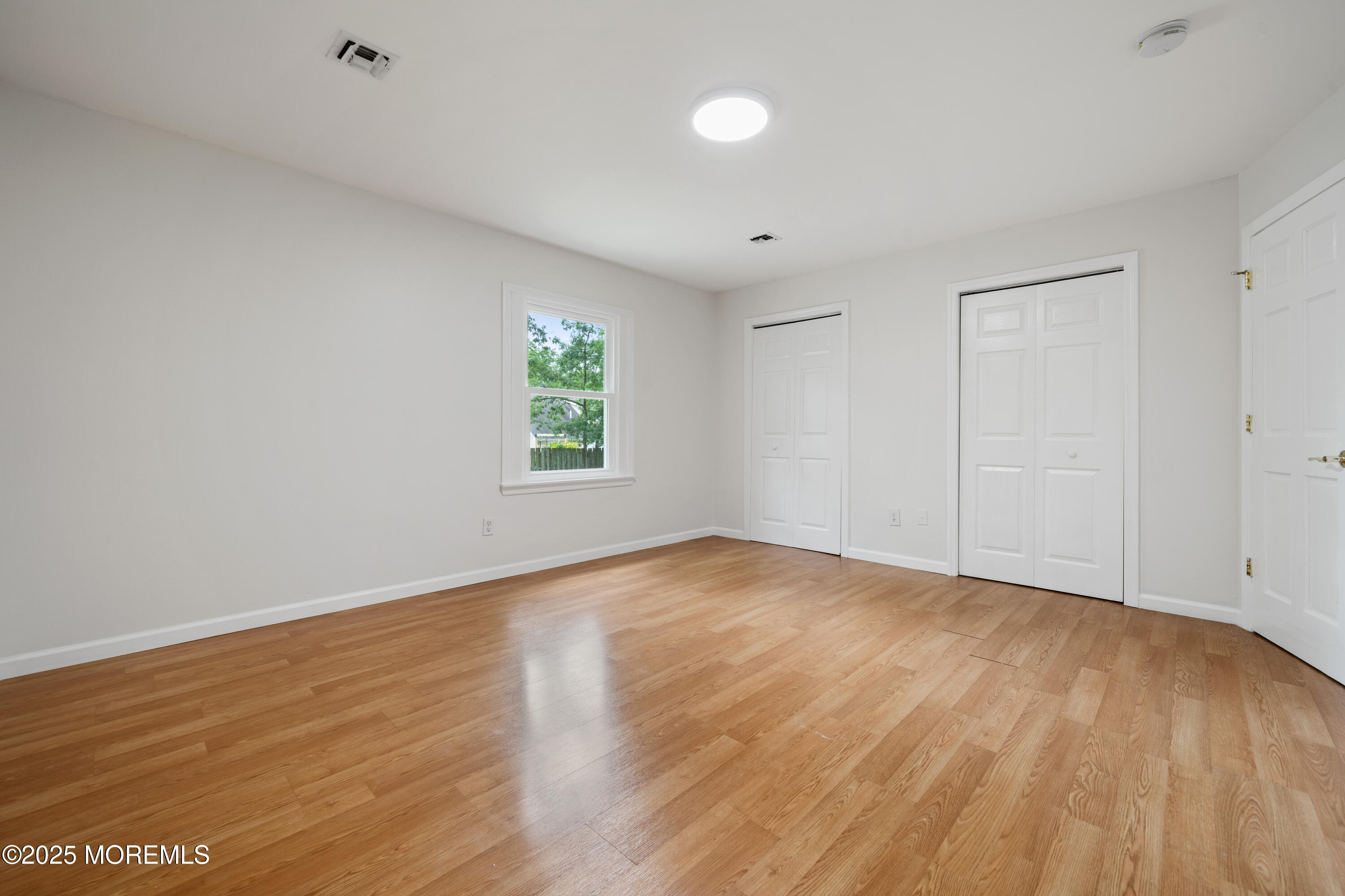 168 Stowaway Road Manahawkin, NJ 08050 - Photo 15 of 15 an empty room with wooden floor and windows