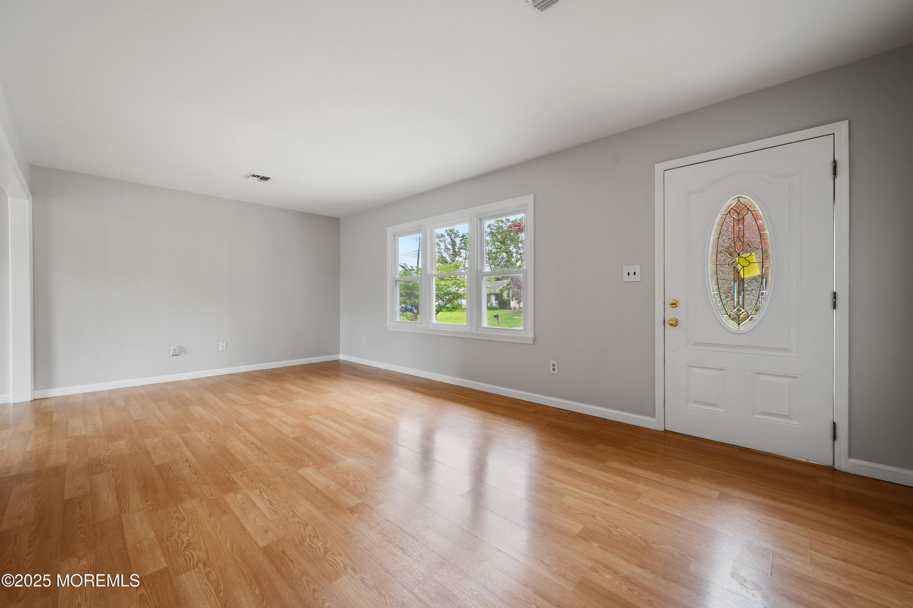 168 Stowaway Road Manahawkin, NJ 08050 - Photo 2 of 15 an empty room with window and wooden floor