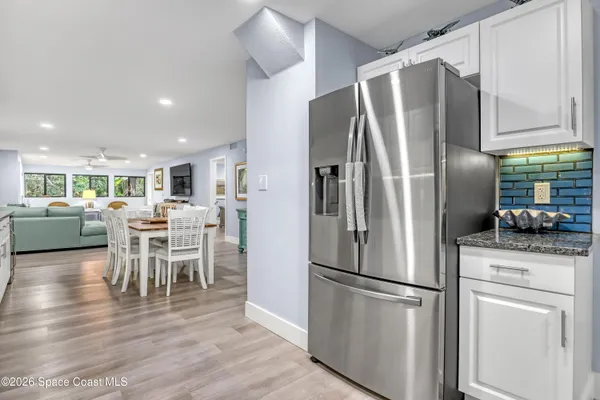 a kitchen with granite countertop a sink stainless steel appliances white cabinets and a counter space
