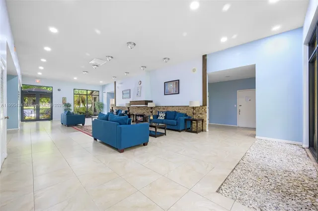 a view of swimming pool with seating space and trees in the background