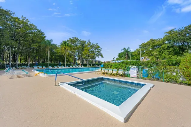 a view of a swimming pool with a bench and trees