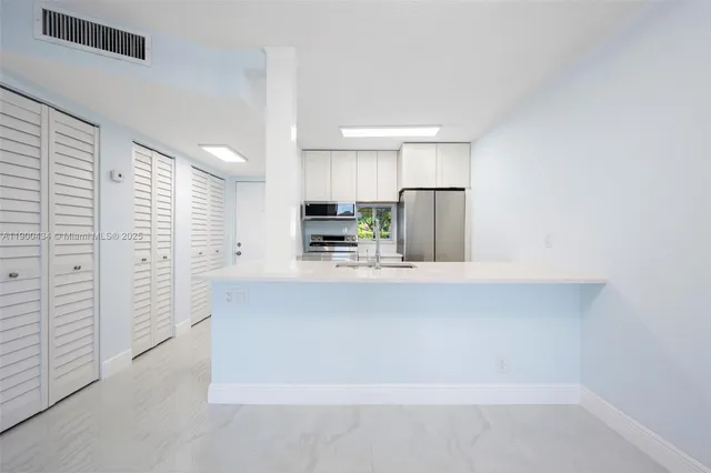 an empty room with windows and mirror