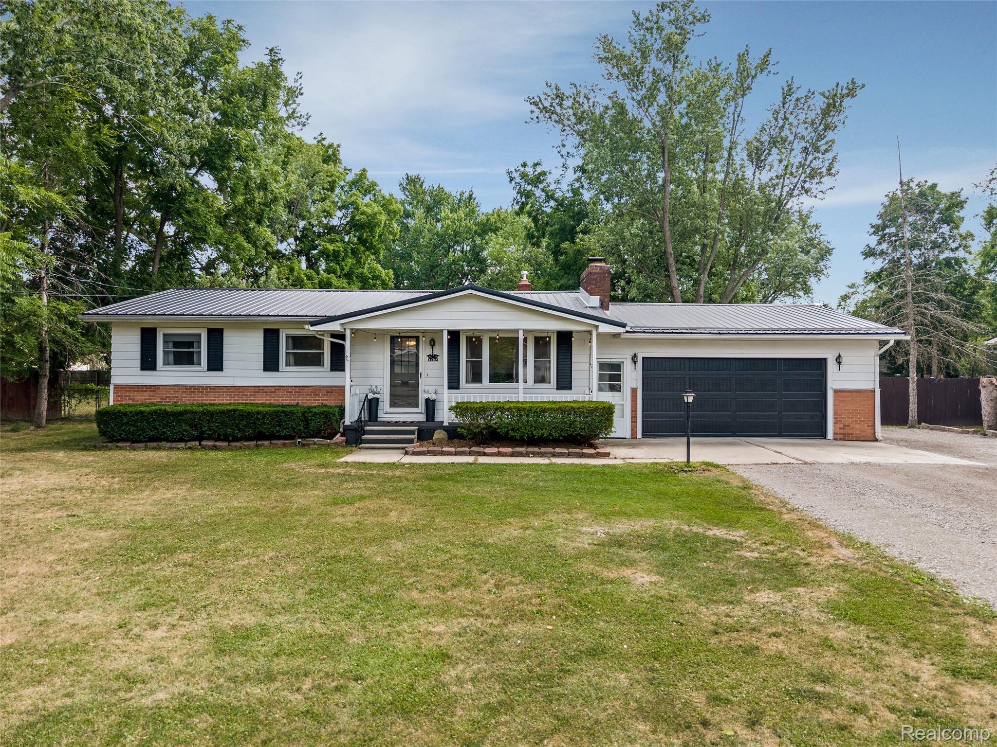 4497 Reid Road Swartz Creek, MI 48473 - Photo 25 of 31 Single-story residence featuring a metal roof, white siding, and a partial brick facade