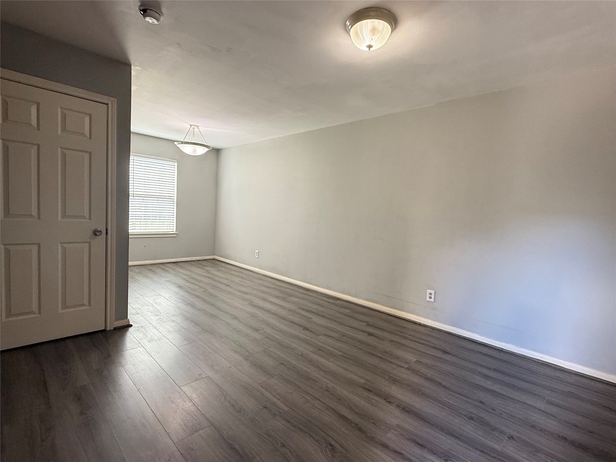 304 Dell Court, Unit 6 Houston, TX 77009 - Photo 11 of 14 an empty room with wooden floor and windows