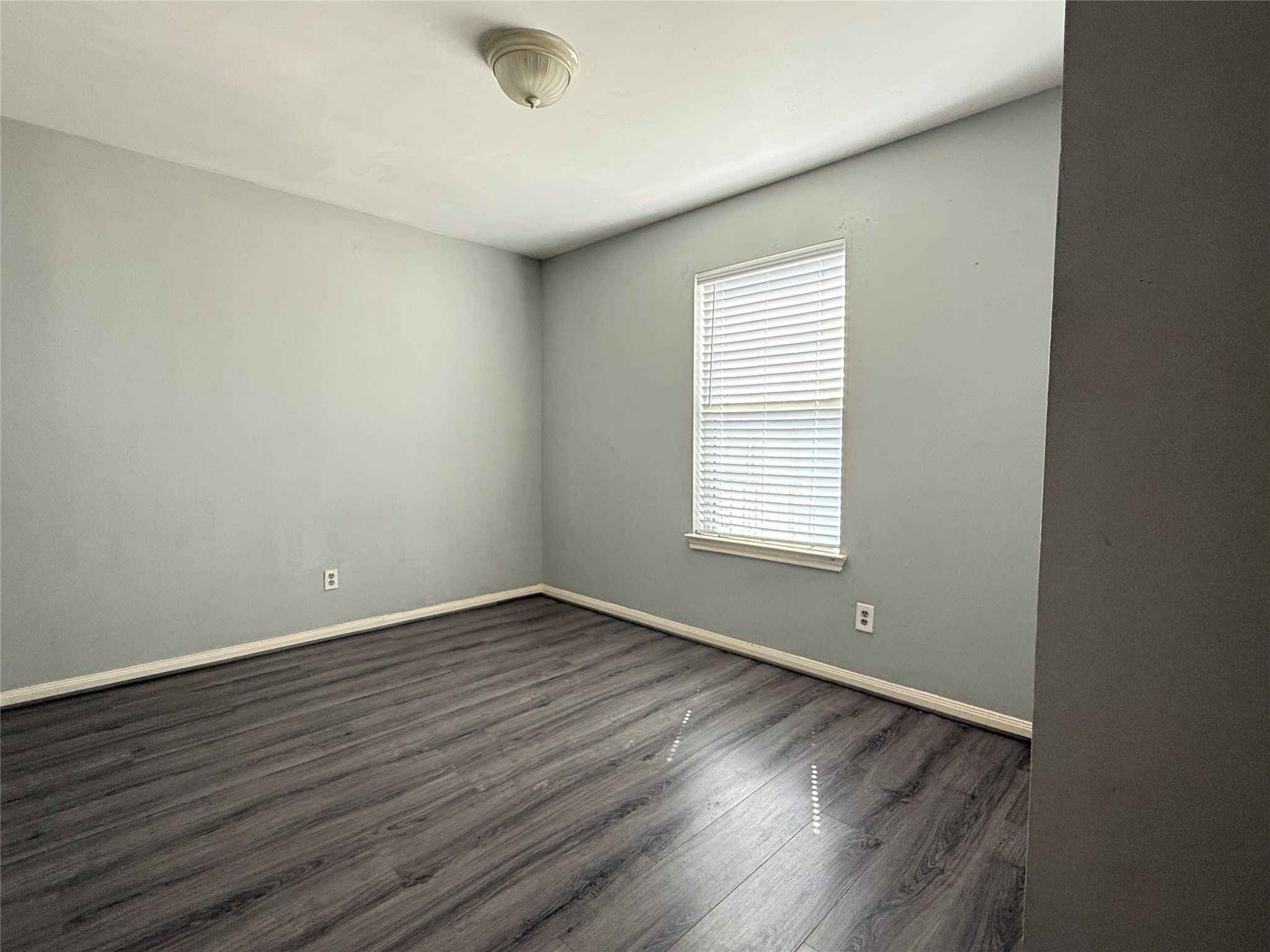 304 Dell Court, Unit 6 Houston, TX 77009 - Photo 12 of 14 an empty room with wooden floor and windows