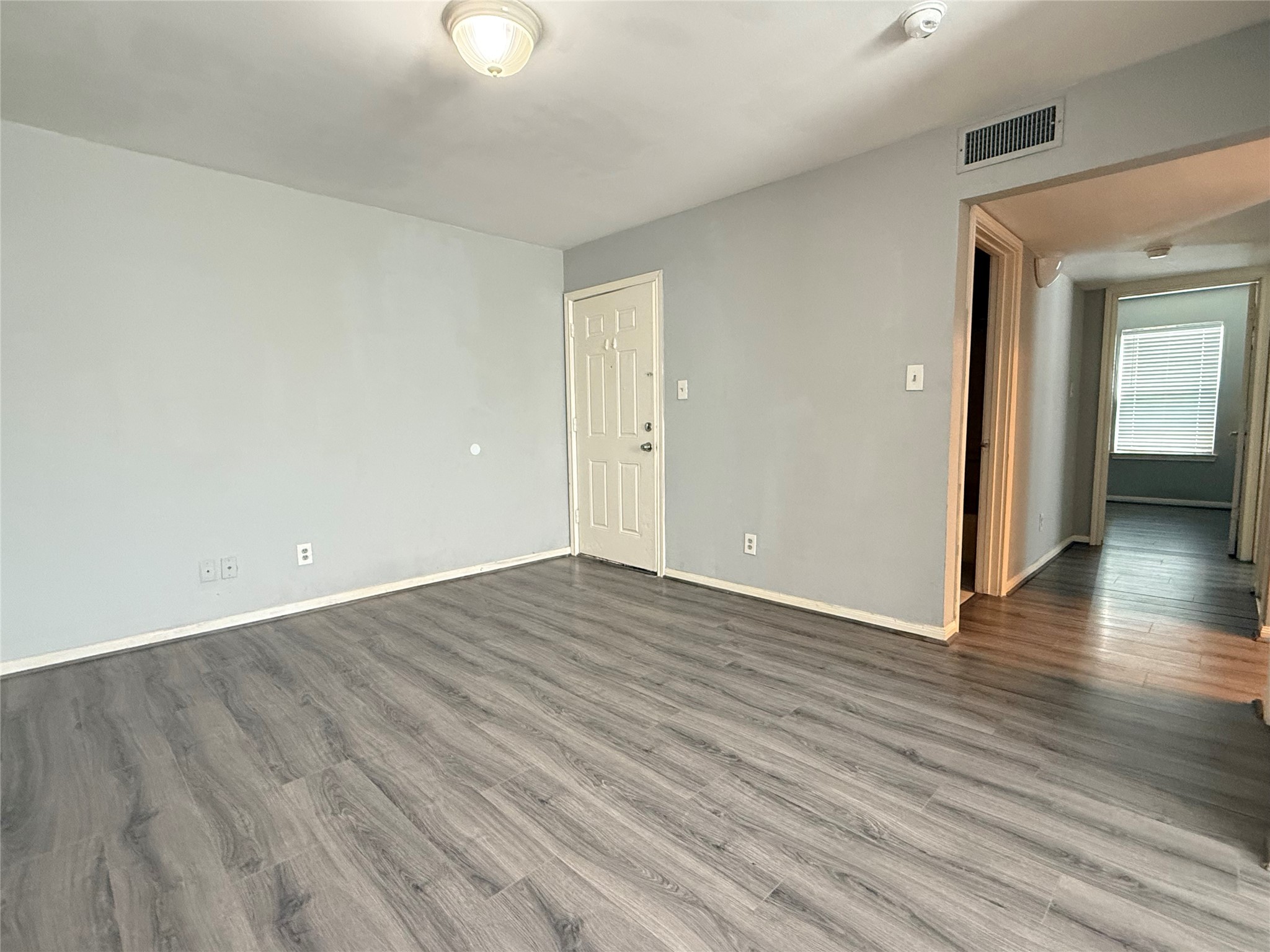 304 Dell Court, Unit 6 Houston, TX 77009 - Photo 13 of 14 a view of an empty room with wooden floor and a window
