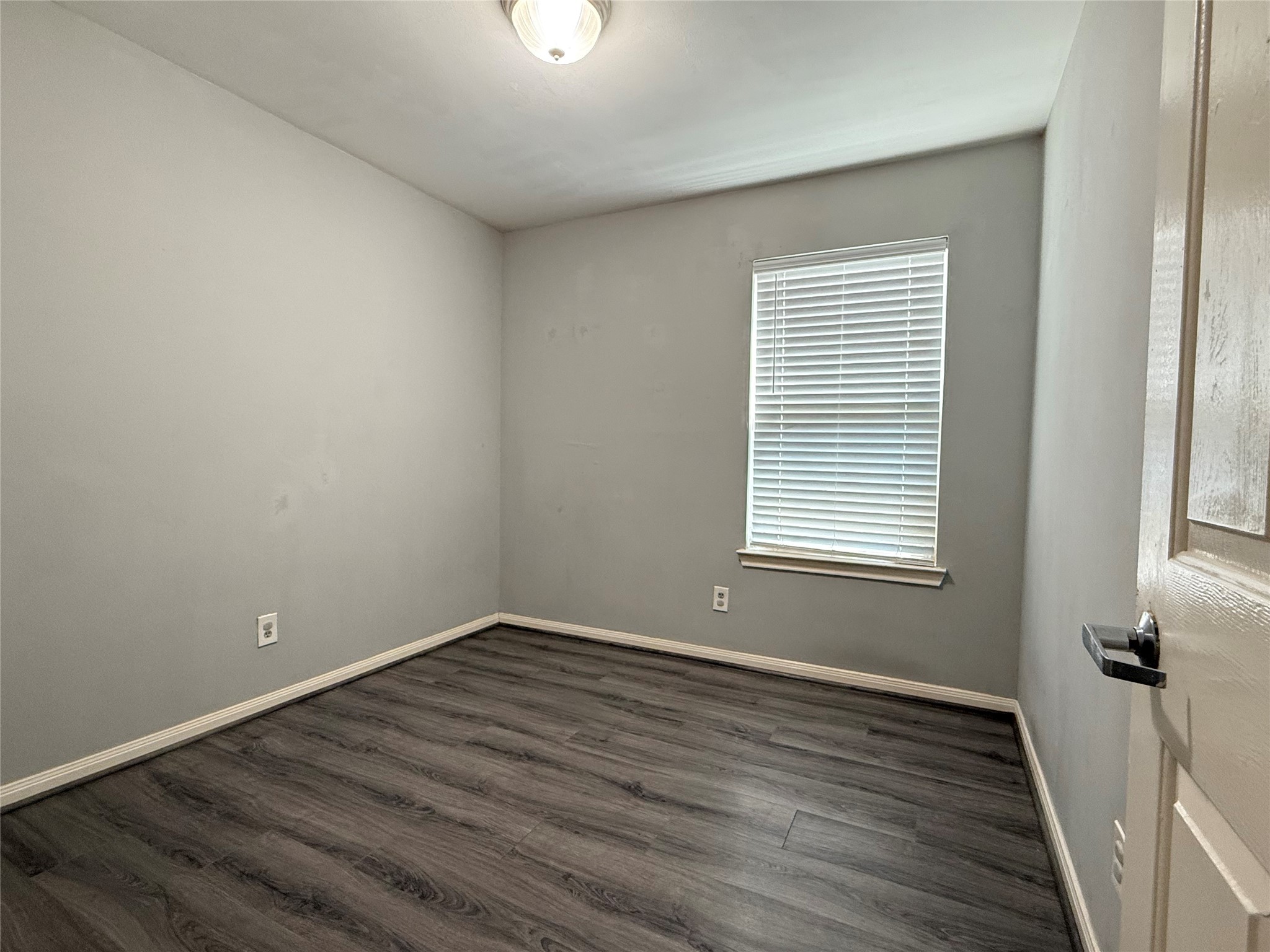 304 Dell Court, Unit 6 Houston, TX 77009 - Photo 10 of 14 wooden floor in an empty room with a window