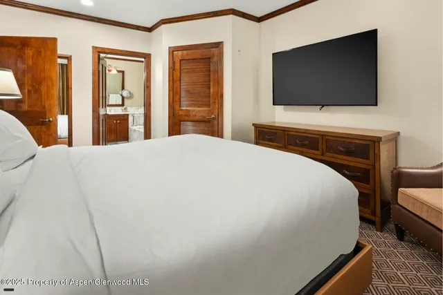 a bedroom with a bed and a flat screen tv