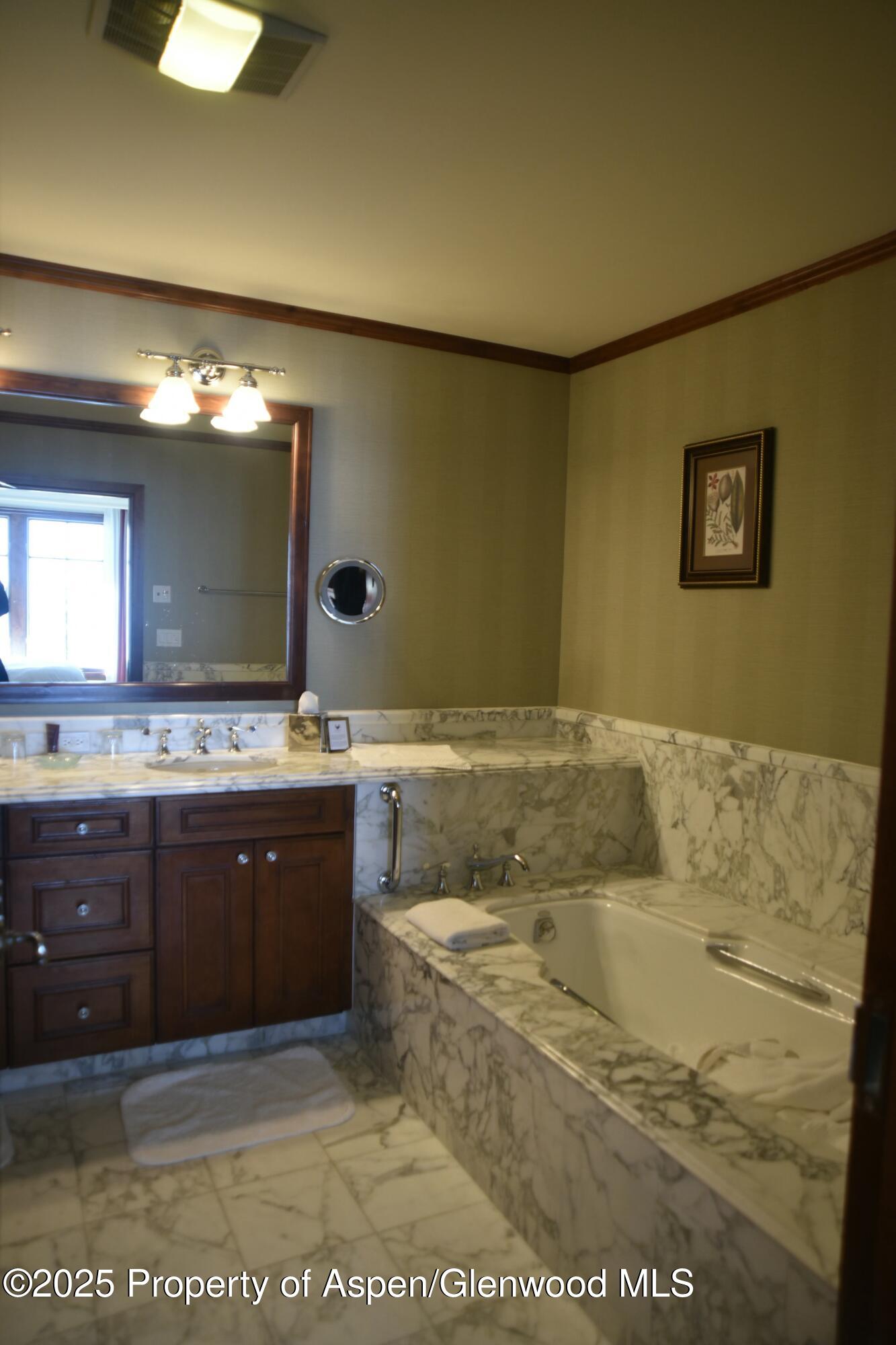 75 Prospector Road, Unit 83034 Aspen, CO 81611 - Photo 13 of 25 a spacious bathroom with a granite countertop sink and a mirror