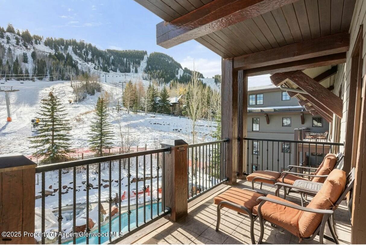 75 Prospector Road, Unit 83034 Aspen, CO 81611 - Photo 2 of 25 a view of a chair and tables in the balcony