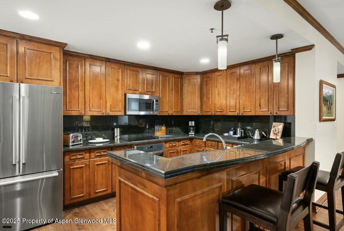 75 Prospector Road, Unit 83034 Aspen, CO 81611 - Photo 6 of 25 a kitchen with a sink a stove and chairs