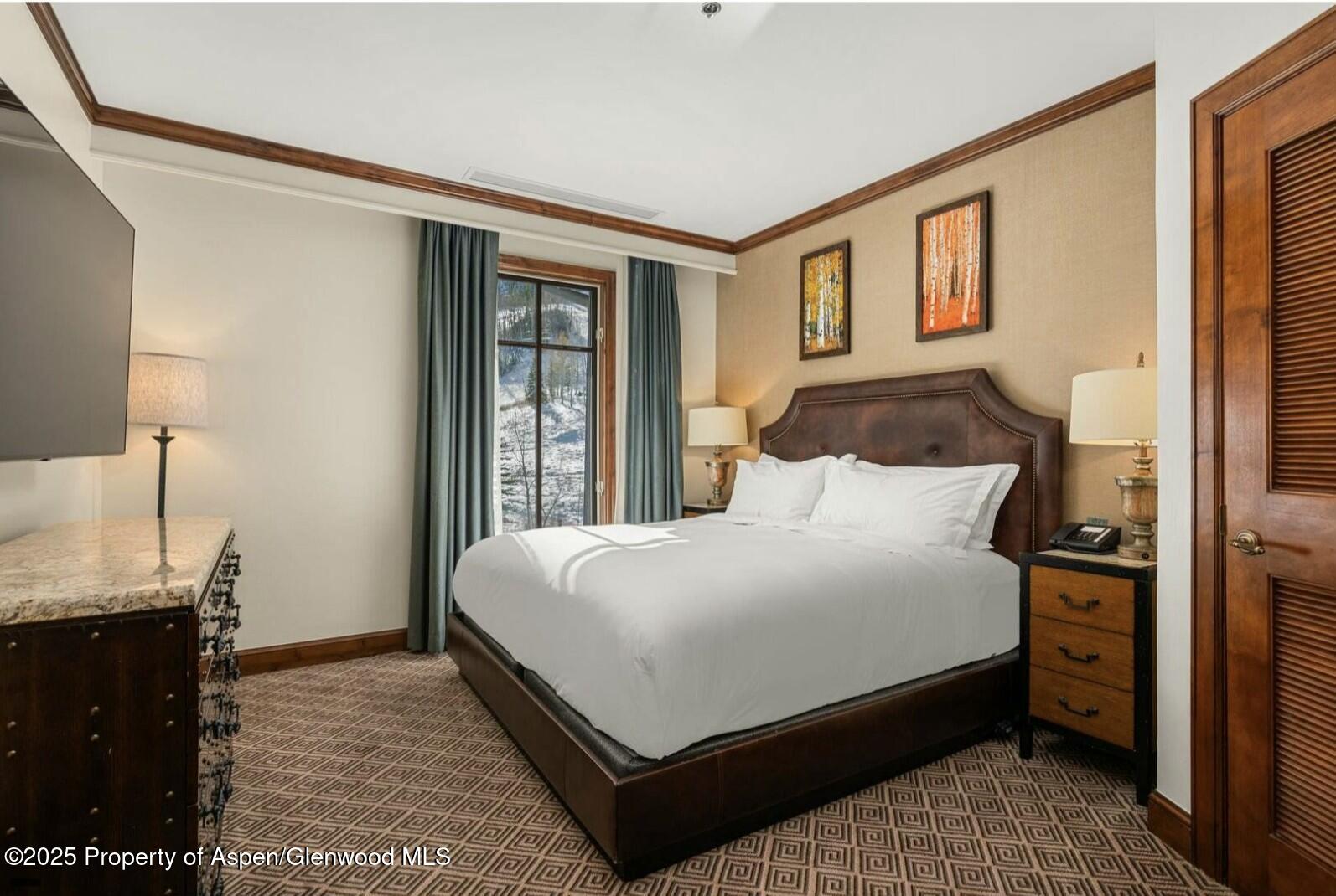 75 Prospector Road, Unit 83034 Aspen, CO 81611 - Photo 9 of 25 a bedroom with a bed and wooden floor