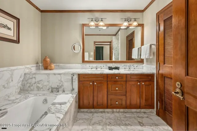 a bathroom with a granite countertop tub sink and mirror