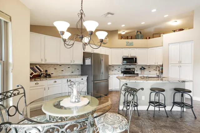 a spacious bedroom with a bed and a chandelier