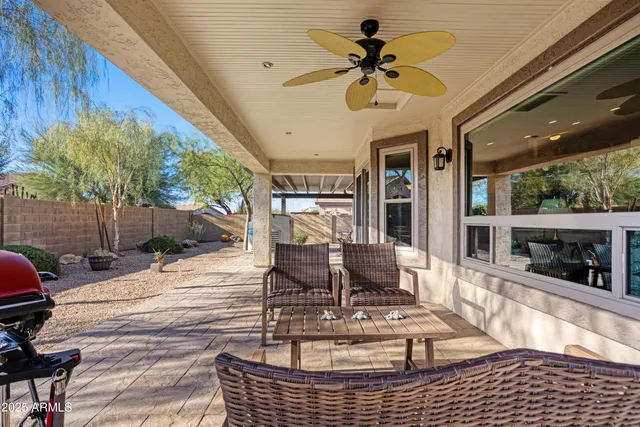 a view of a patio with table and chairs potted plants with floor to ceiling window