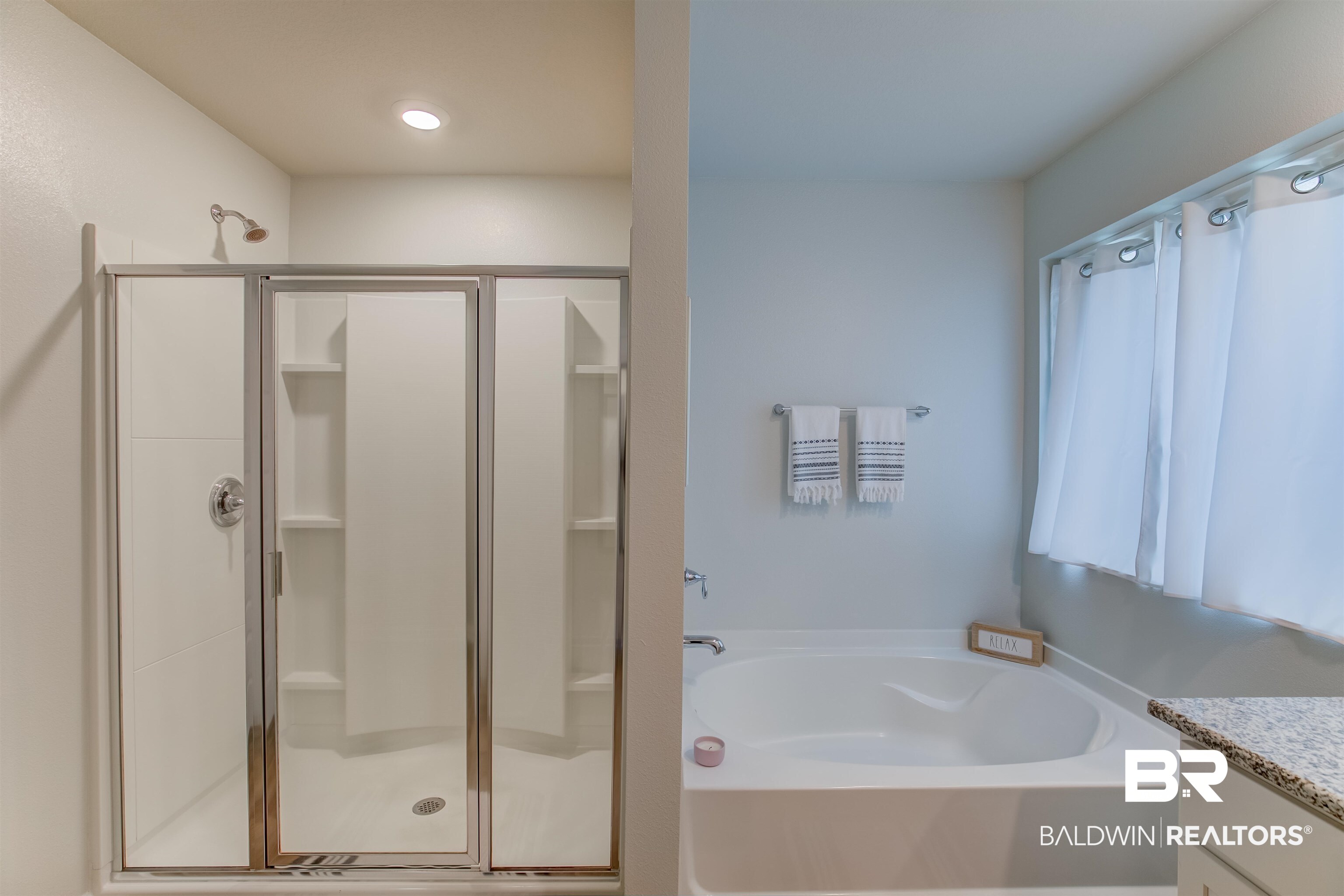 8033 Irwin Loop Daphne, AL 36526 - Photo 25 of 38 Bright bathroom featuring a walk-in shower with clear glass enclosure, built-in shelving, and a separate soaking tub