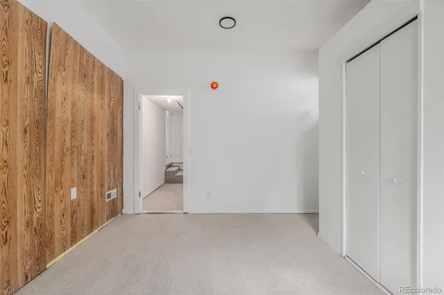 an empty room with a hallway view and window