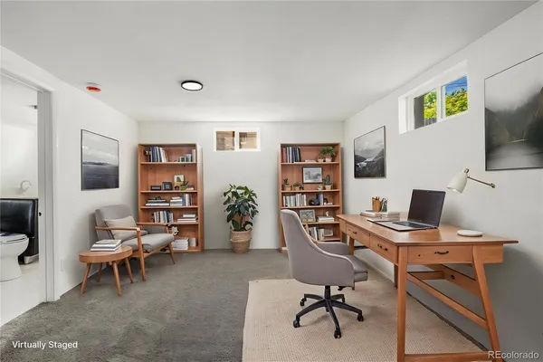 a view of a workspace with furniture and a window
