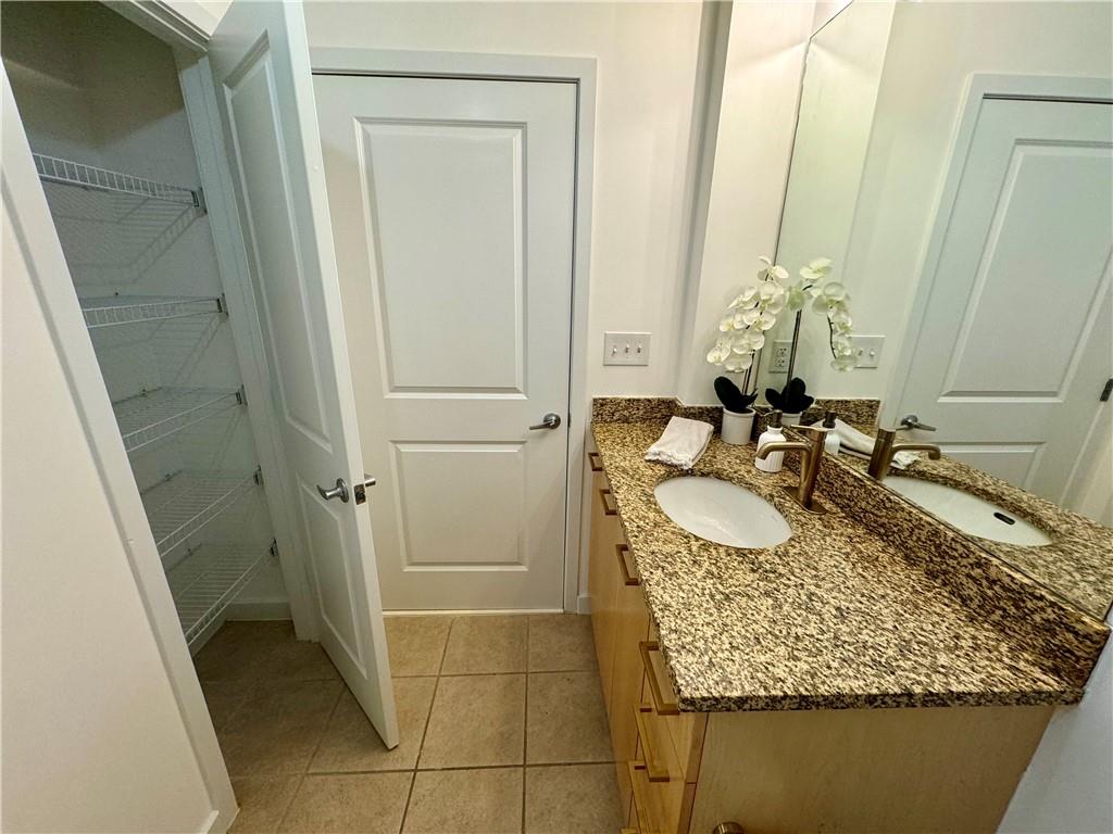 3324 Peachtree Road Northeast, Unit 2307 Atlanta, GA 30326 - Photo 16 of 42 a bathroom with a granite countertop sink and a mirror