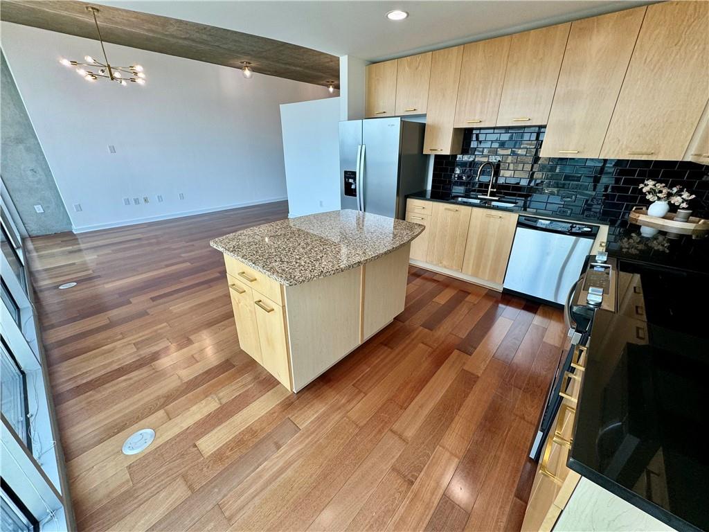 3324 Peachtree Road Northeast, Unit 2307 Atlanta, GA 30326 - Photo 8 of 42 a kitchen with stainless steel appliances wooden floors wooden cabinets a refrigerator and a stove