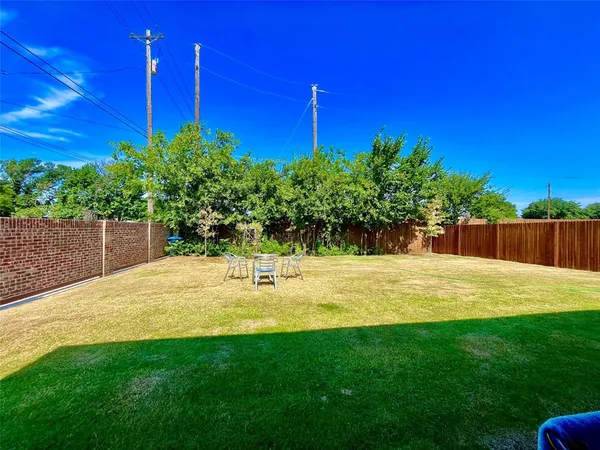 a view of a yard with plants and a building
