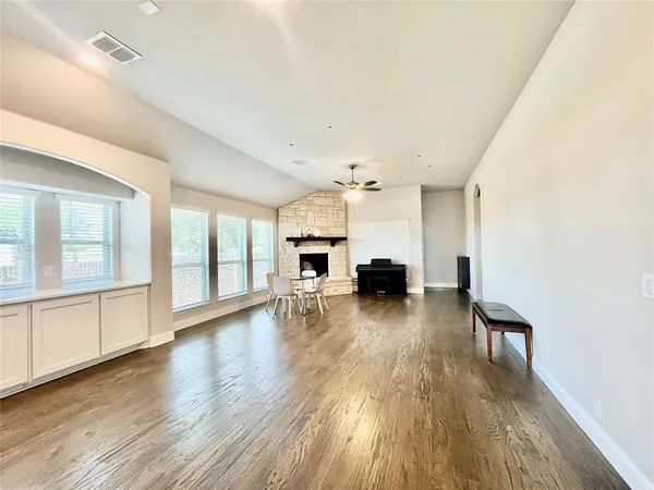 a kitchen that has a lot of white cabinets and wooden floor