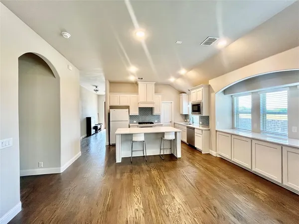 a kitchen with stainless steel appliances granite countertop a stove a sink and a microwave