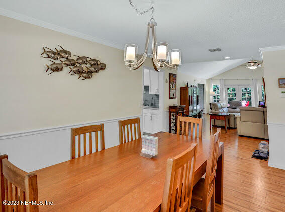1910 Shadow Ridge Trail Jacksonville, FL 32225 - Photo 11 of 21 a dining room with wooden floor a chandelier a wooden table and chairs