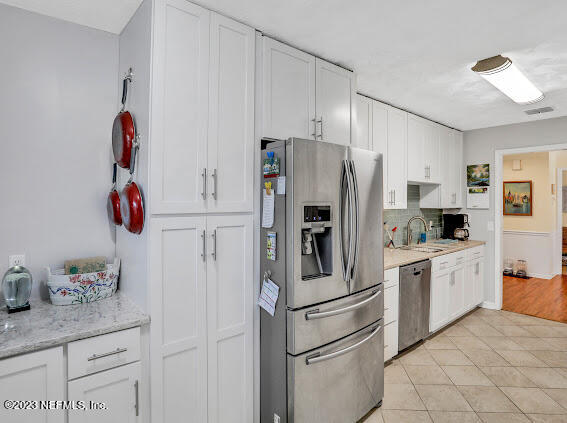 1910 Shadow Ridge Trail Jacksonville, FL 32225 - Photo 17 of 21 a kitchen with stainless steel appliances white cabinets and white appliances