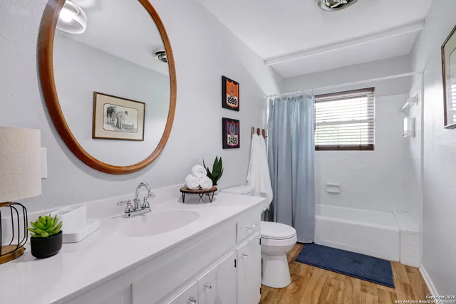 a bathroom with a toilet a sink a mirror a vanity and window