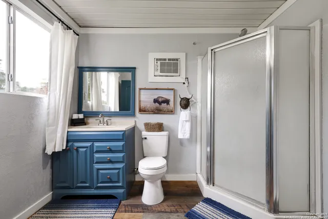 a bathroom with a sink a toilet and shower