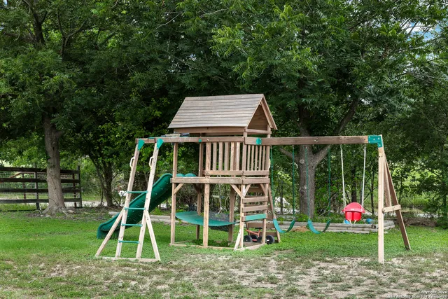 a view of a wooden deck with a big yard and potted plants