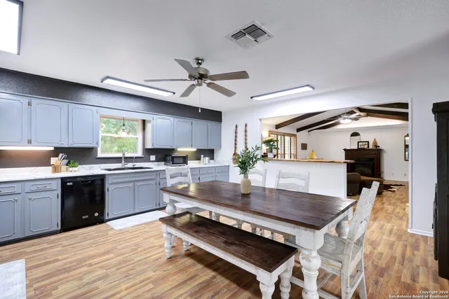 a large kitchen with kitchen island a stove a sink a dining table and chairs