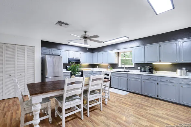 a kitchen with a table chairs refrigerator and cabinets
