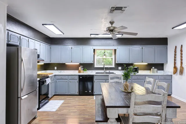 a kitchen with cabinets a counter space stainless steel appliances and a window
