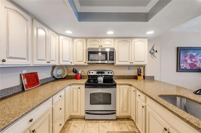 a kitchen with granite countertop a stove top oven microwave and cabinets