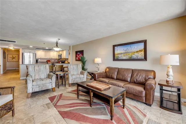 a living room with furniture kitchen view and a table