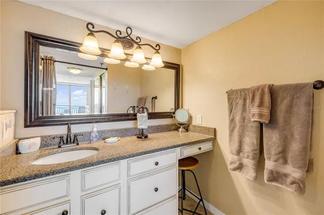 a bathroom with a granite countertop sink and a mirror