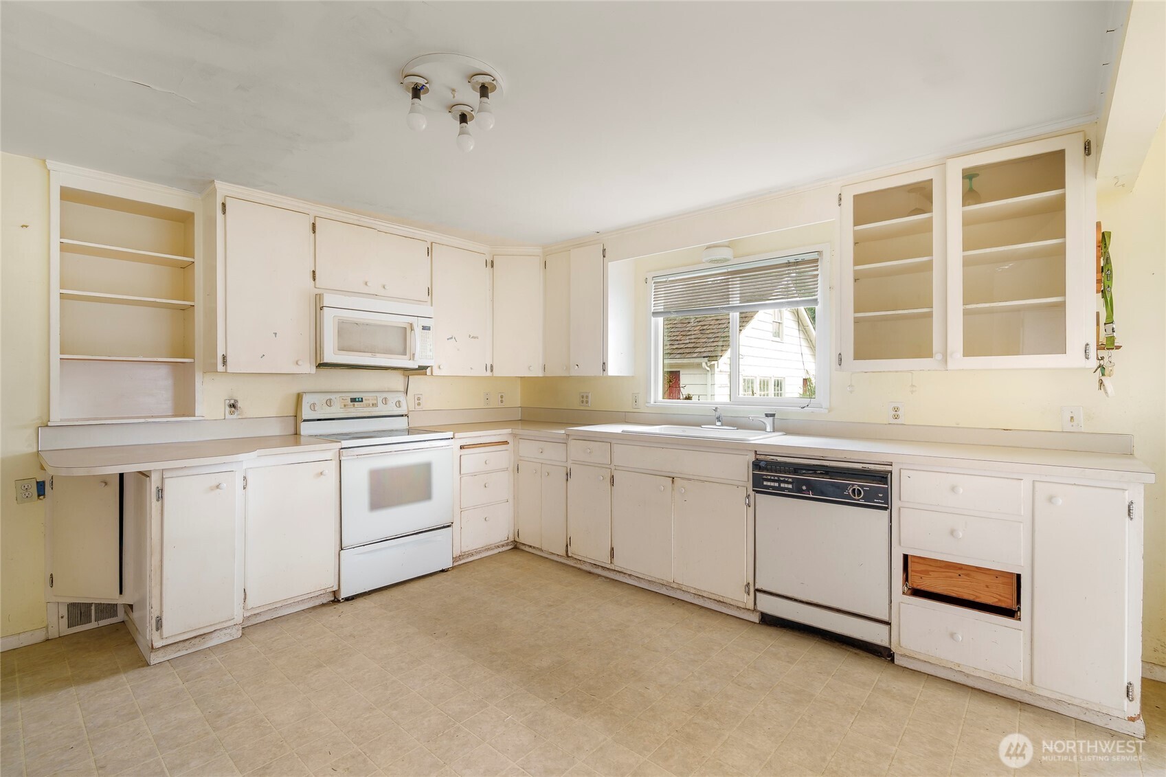 1020 Puget Drive Edmonds, WA 98020 - Photo 7 of 22 a kitchen with granite countertop white cabinets and white appliances
