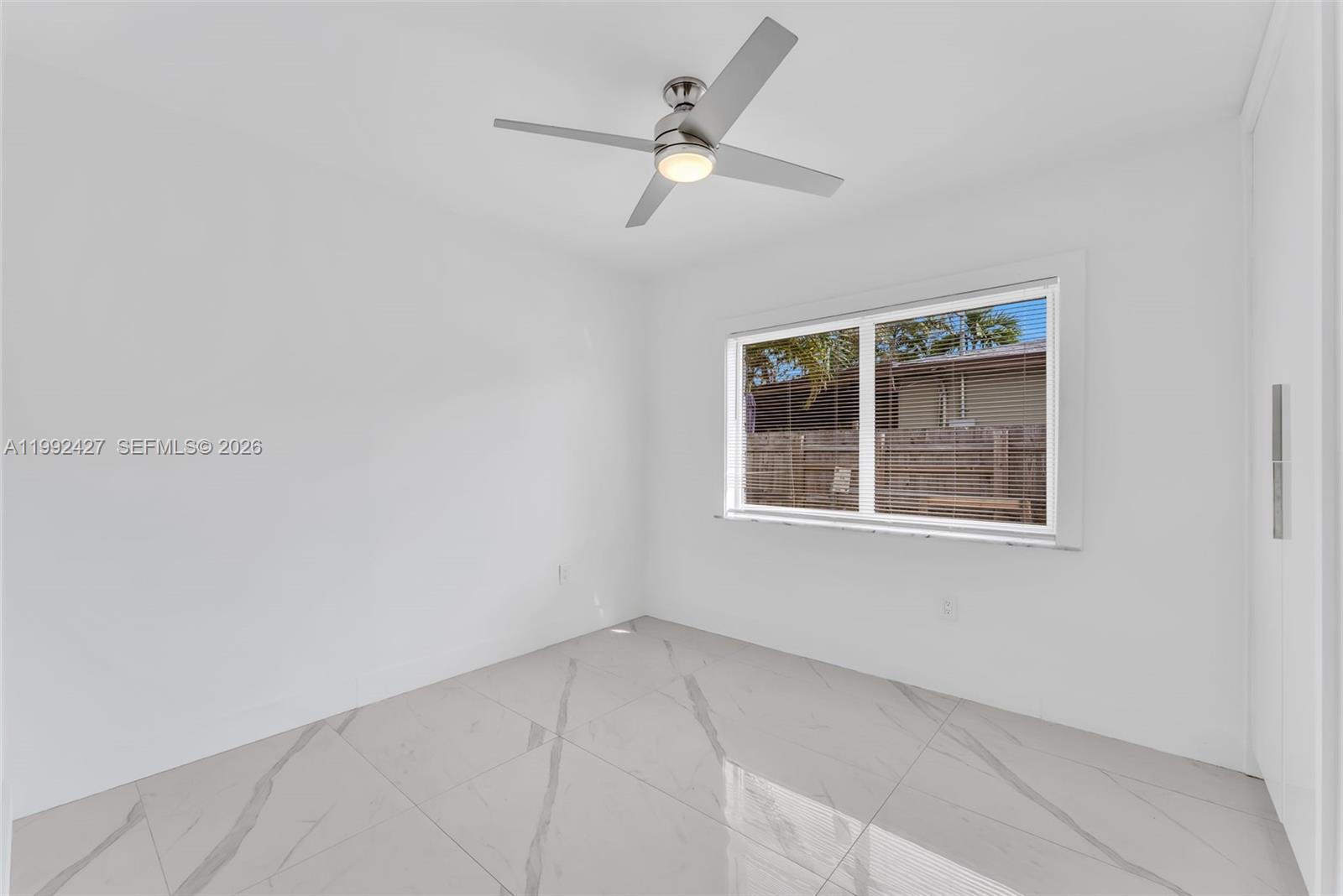 875 East 8th Street Hialeah, FL 33010 - Photo 13 of 36 an empty room with a window and a fan