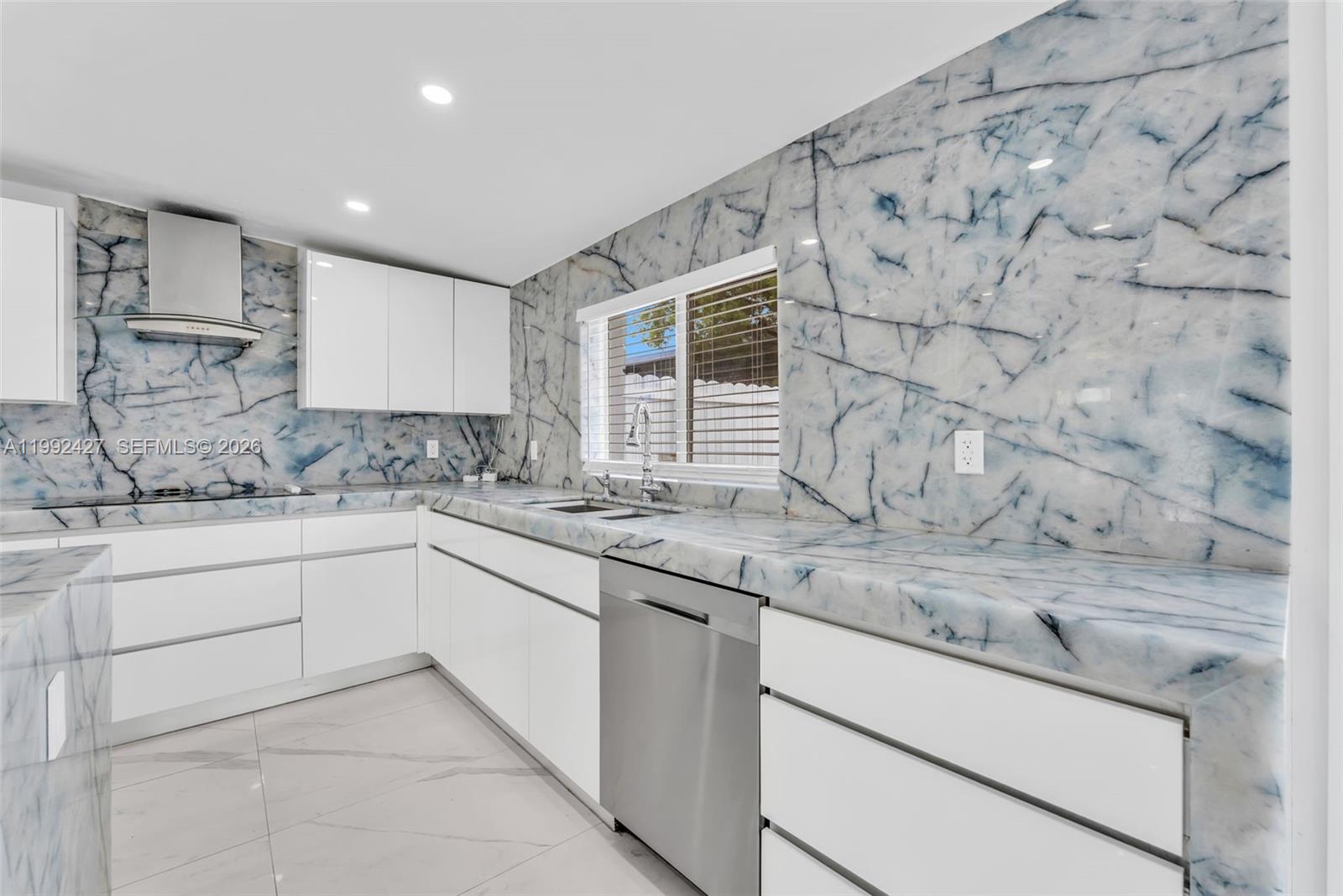 875 East 8th Street Hialeah, FL 33010 - Photo 5 of 36 a kitchen with granite countertop white cabinets and white appliances