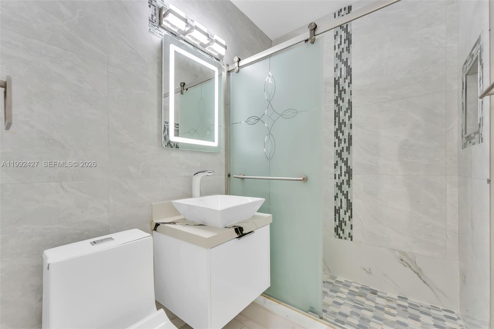 875 East 8th Street Hialeah, FL 33010 - Photo 10 of 36 a bathroom with a sink a toilet and shower