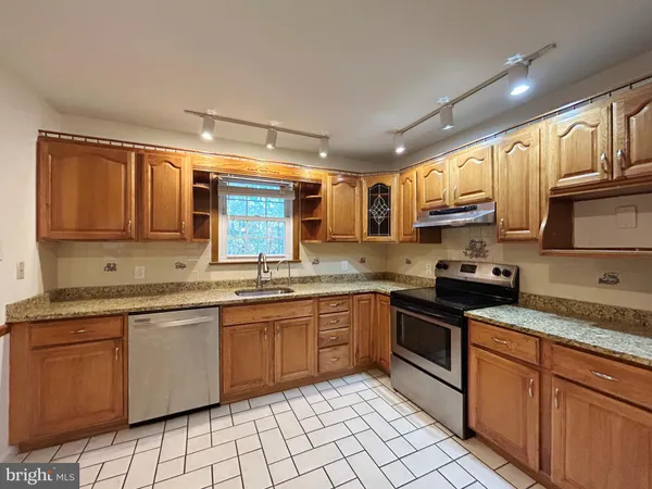 a kitchen with stainless steel appliances a sink and a refrigerator