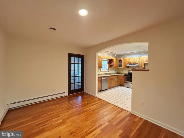 a view of empty room with wooden floor