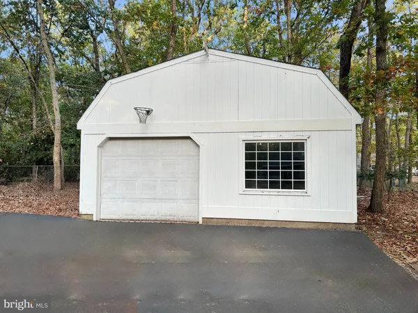 a view of a trees and barn in the middle of a yard