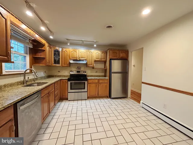 a kitchen with stainless steel appliances granite countertop a sink and cabinets