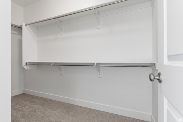 58 South Crimson Way, Unit 306 Mapleton, UT 84664 - Photo 20 of 24 Walk-in closet with carpet flooring, white walls, white shelving, and chrome hanging rods