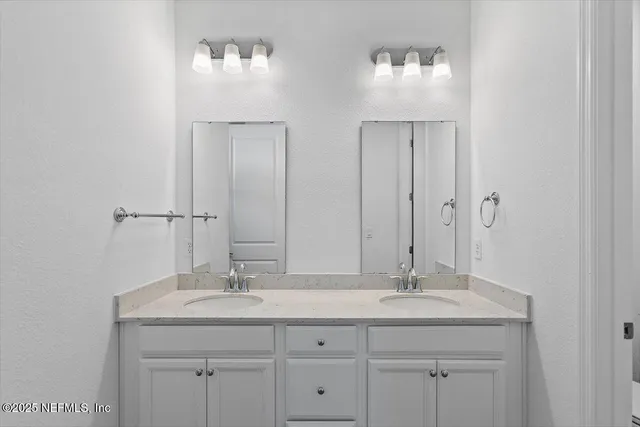 a bathroom with double sink and a mirror